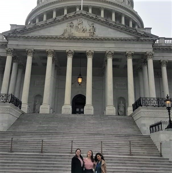 three students in front of Capitol building in Washington D.C.